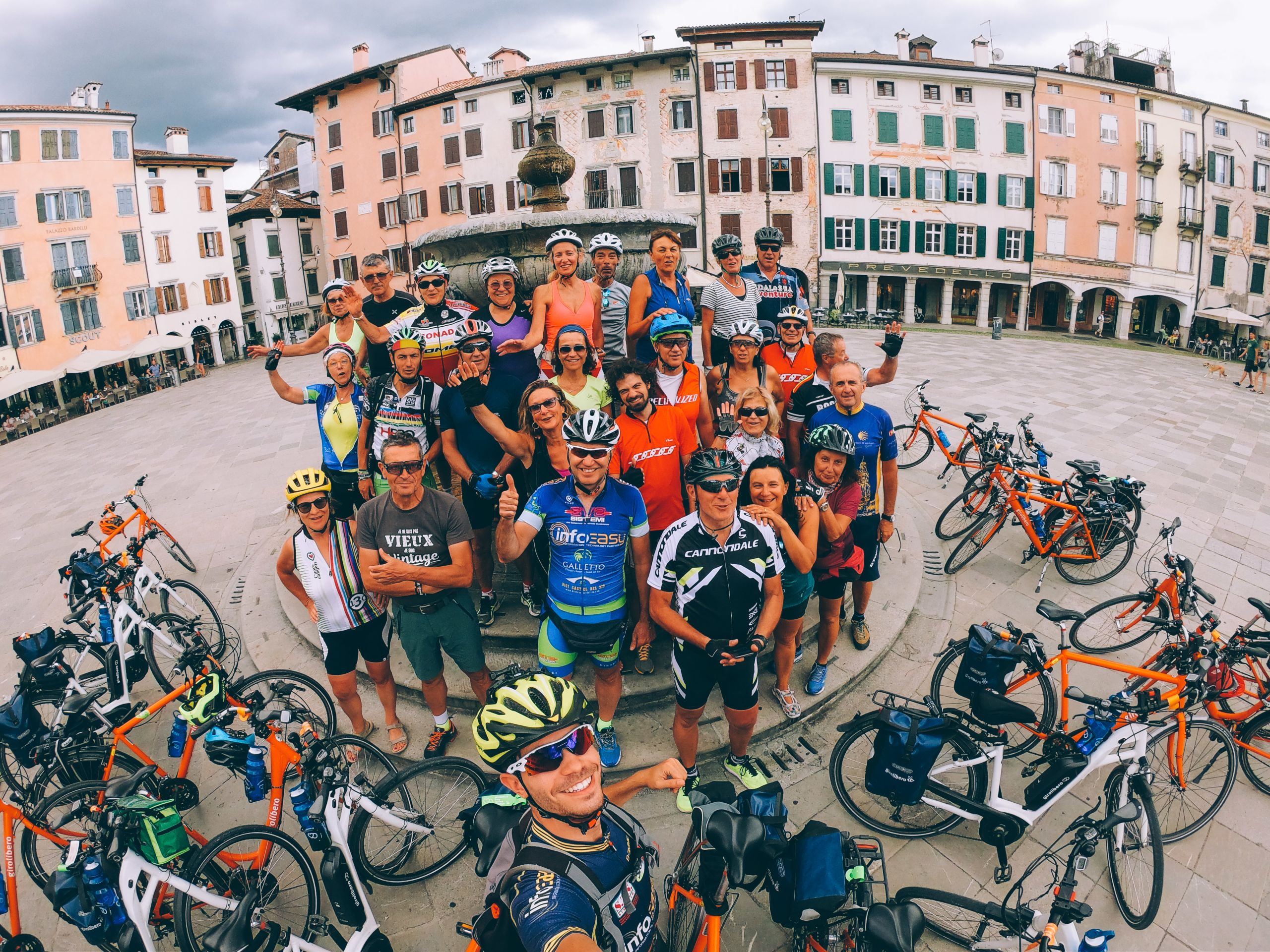 Gruppo di ciclisti in una piazza di Bolzano percorrendo la ciclovia Alpe Adria